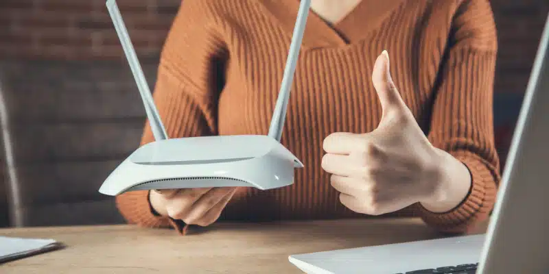 How to Boost Your Wi-Fi Signal Tips for a Stronger, Faster Connection Image showing a person using a laptop with strong Wi-Fi signal bars in a modern home.